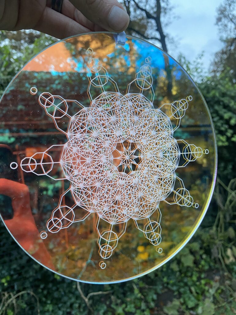 Intricate geometric glass art featuring a circular design with a central star pattern and connecting lines, showcasing craftsmanship.