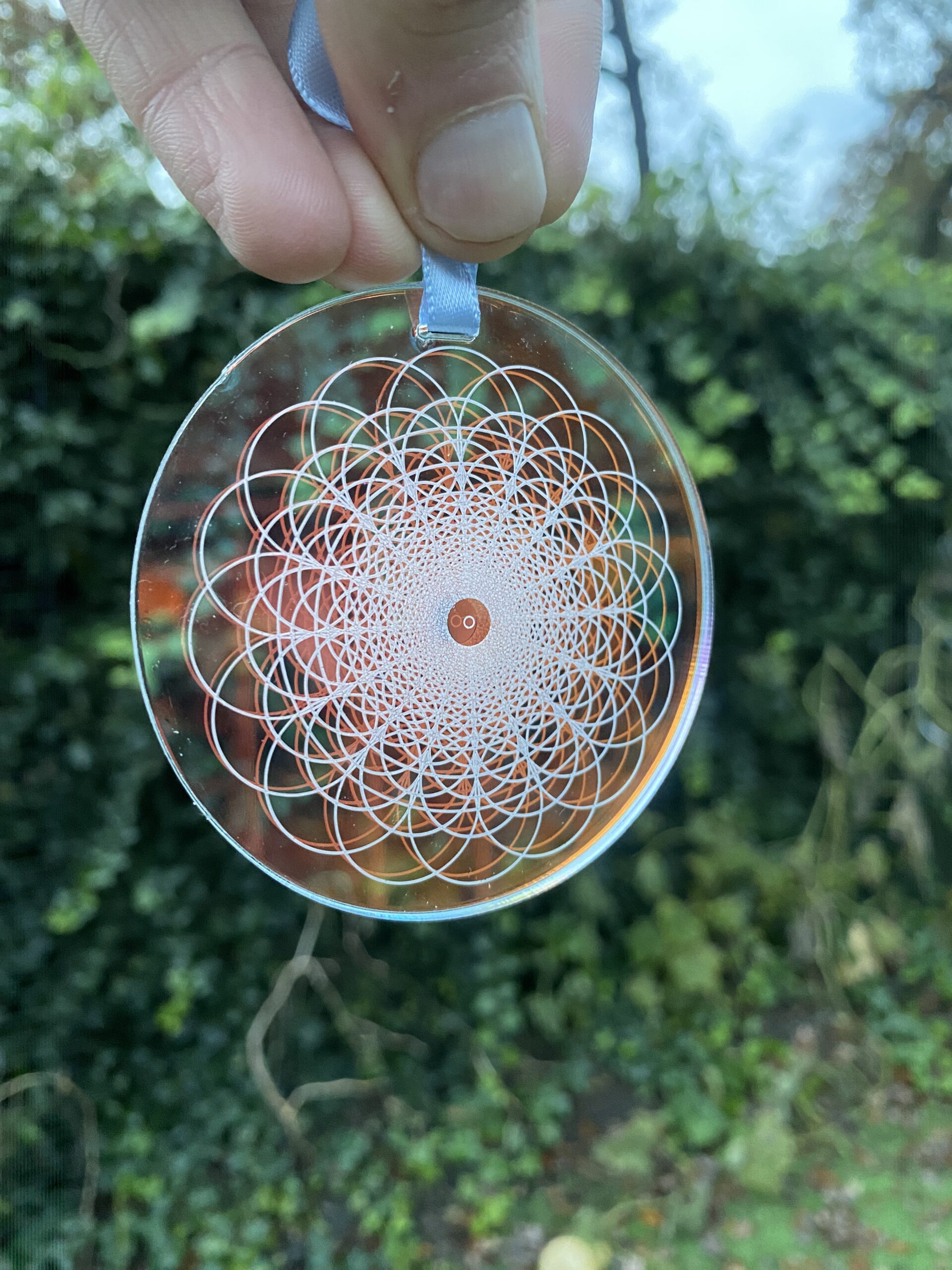 Clear glass ornament featuring intricate geometric pattern with concentric circles and a central design, ideal for decorative purposes.