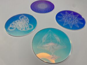 Set of four geometric pattern coasters featuring intricate designs in blue and purple hues, ideal for home decor and functional use.