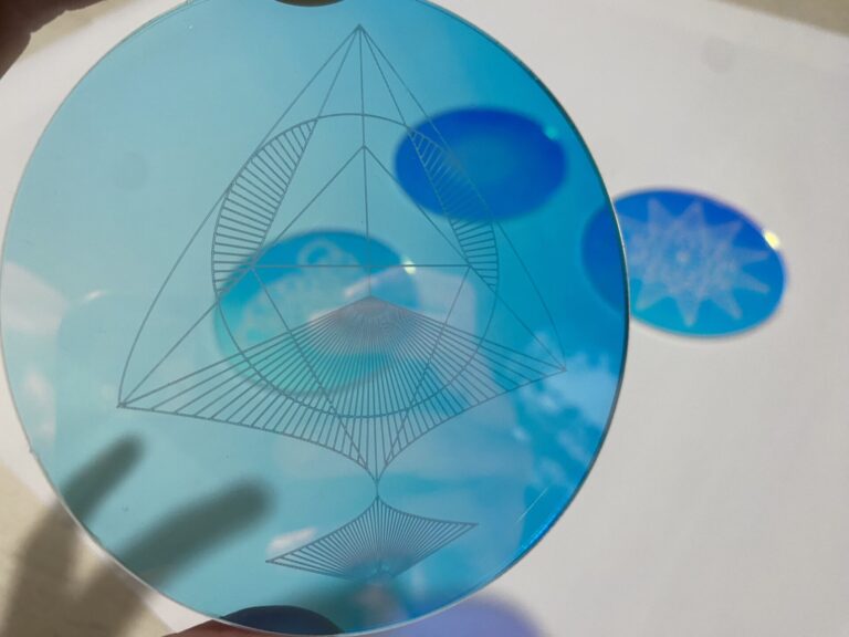 Blauwe optische glazen schijf met geometrische design, ideaal voor wetenschappelijke en artistieke toepassingen, die ingewikkelde patronen laat zien.