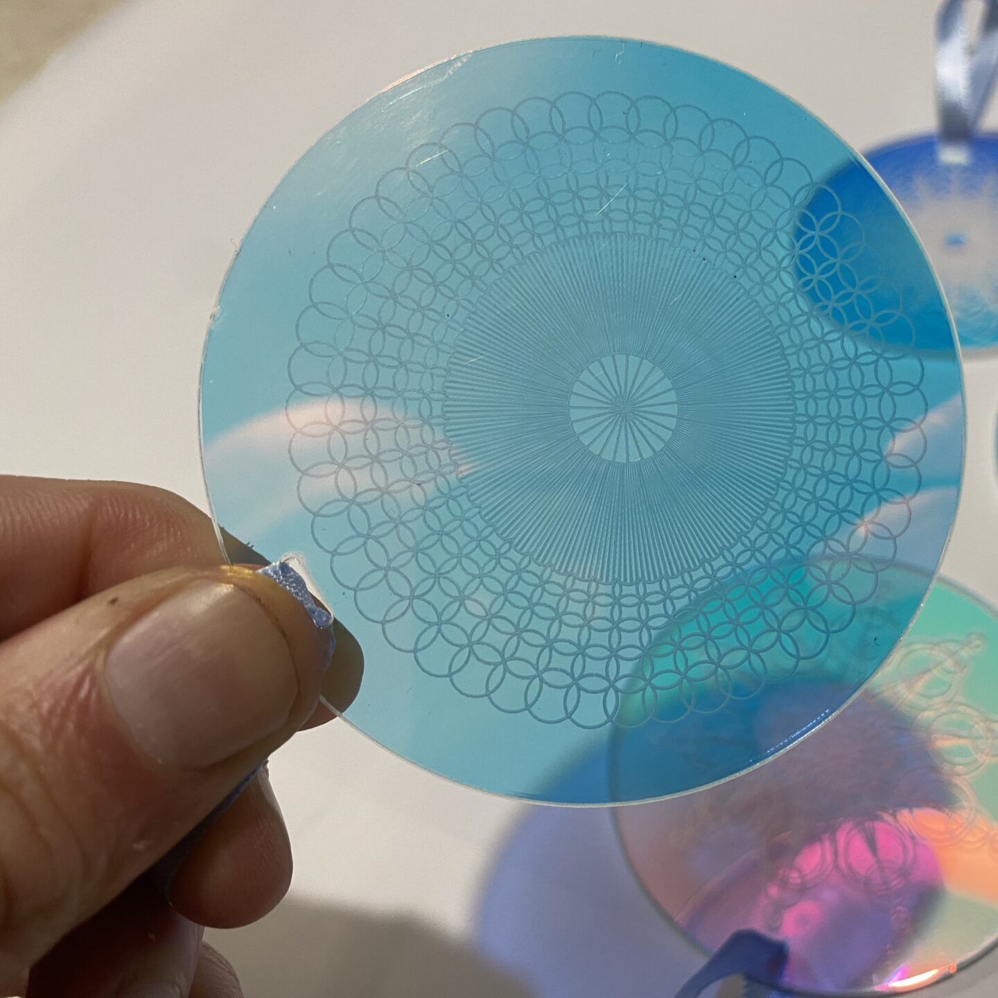 Set of decorative acrylic discs featuring intricate geometric patterns in blue and transparent designs, ideal for crafting and decor.