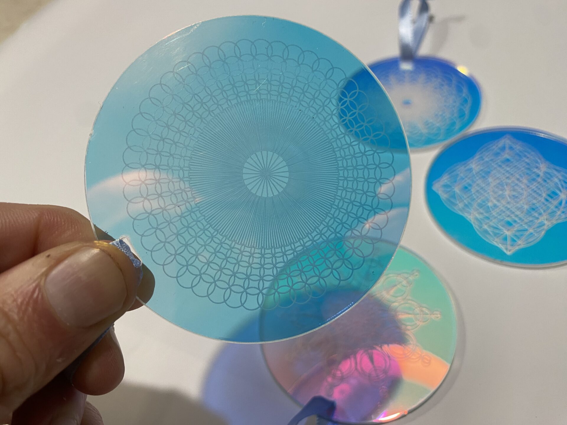Set of decorative acrylic discs featuring intricate geometric patterns in blue and transparent designs, ideal for crafting and decor.