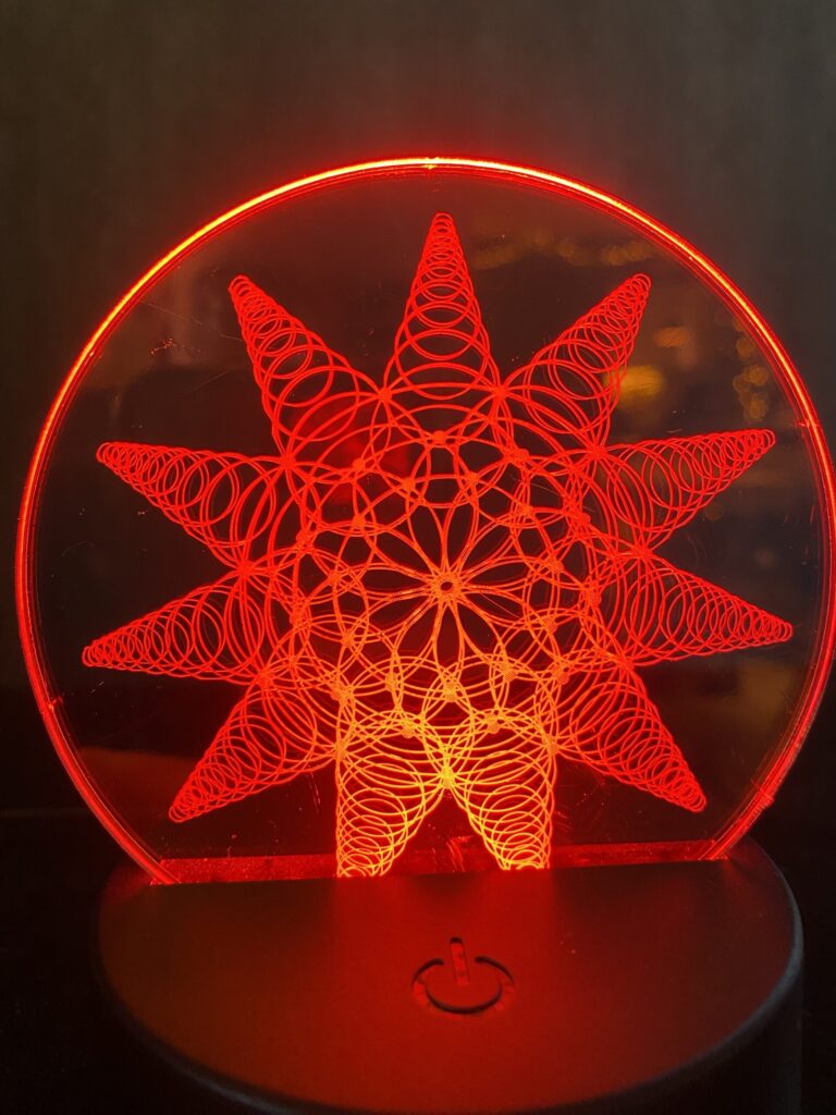 Red LED lamp featuring a geometric star pattern design, creating a captivating light display for home decor.