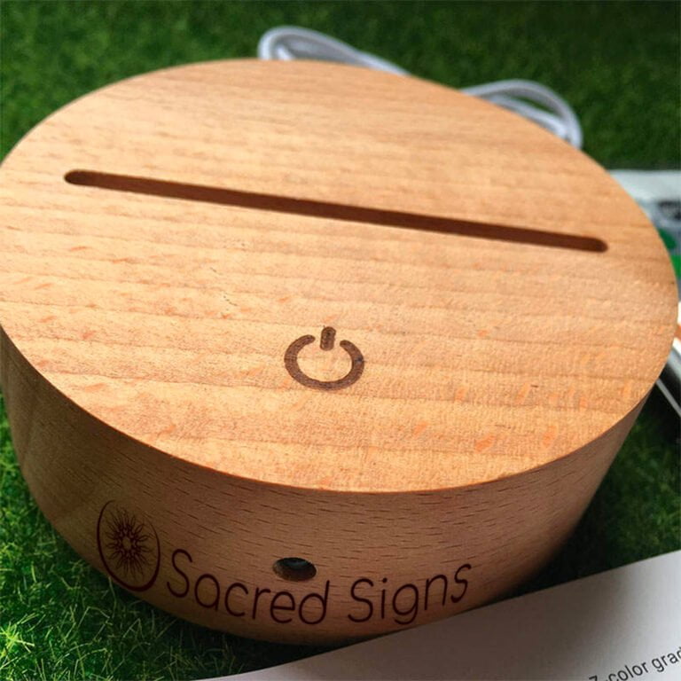 Wooden device with a power button and slot, branded with Sacred Signs logo, designed for various electronic uses.